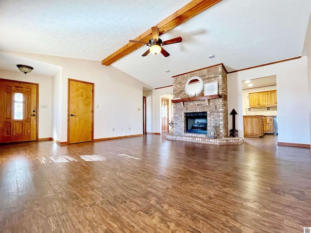 unfurnished living room featuring dark hardwood / wood-style floors, lofted ceiling with beams, a brick fireplace, and a textured ceiling