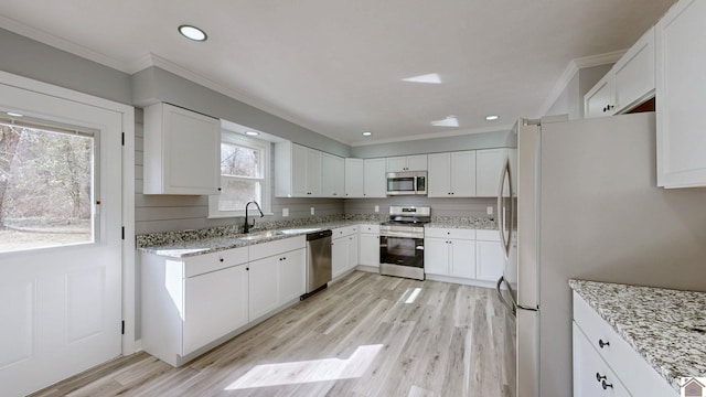 kitchen featuring white cabinetry, light stone counters, and appliances with stainless steel finishes