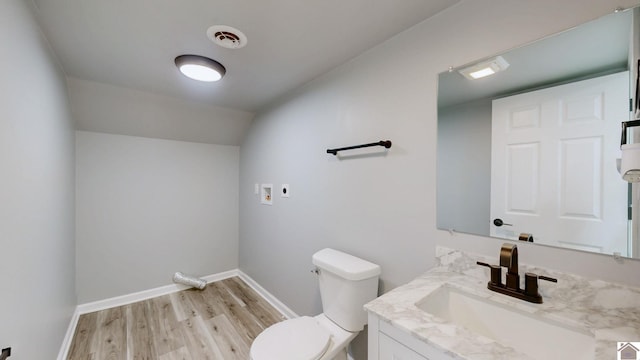 bathroom with vanity, hardwood / wood-style flooring, vaulted ceiling, and toilet