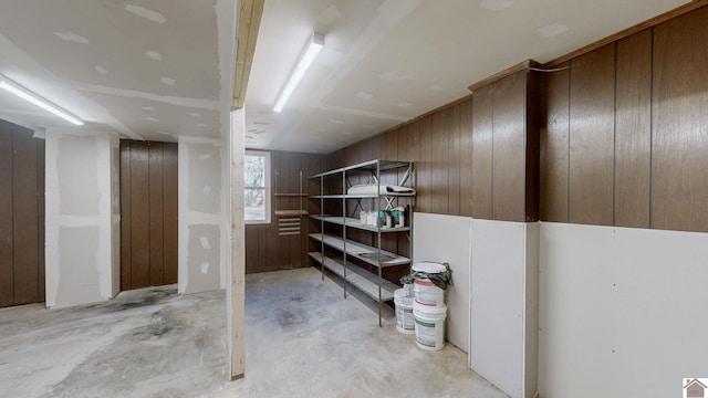 basement featuring wooden walls