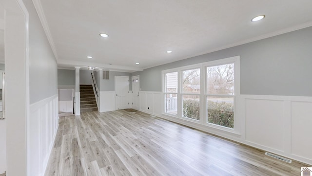 unfurnished living room with crown molding and light hardwood / wood-style floors