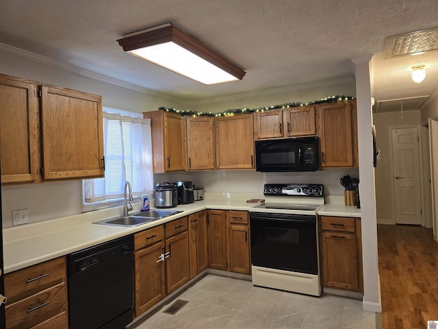 kitchen with sink, ornamental molding, black appliances, and a textured ceiling