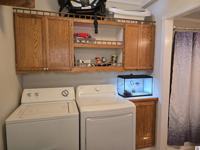 laundry area with washer and clothes dryer and cabinets