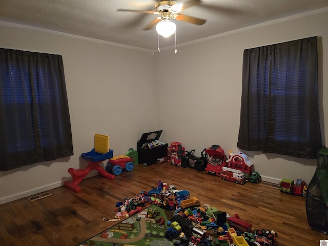 playroom with crown molding, ceiling fan, and hardwood / wood-style flooring