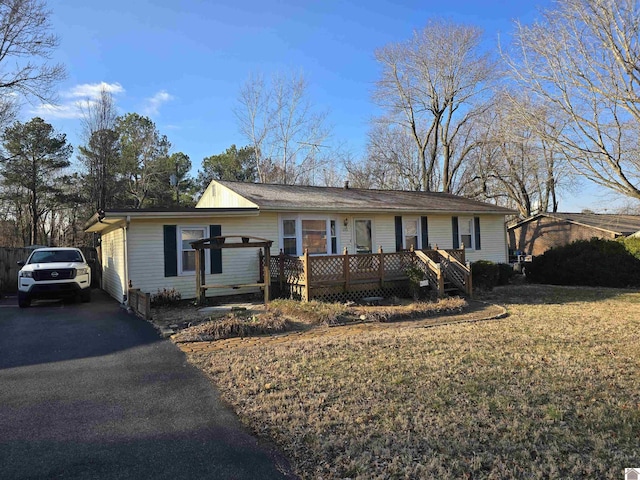 ranch-style home with a wooden deck and a front yard