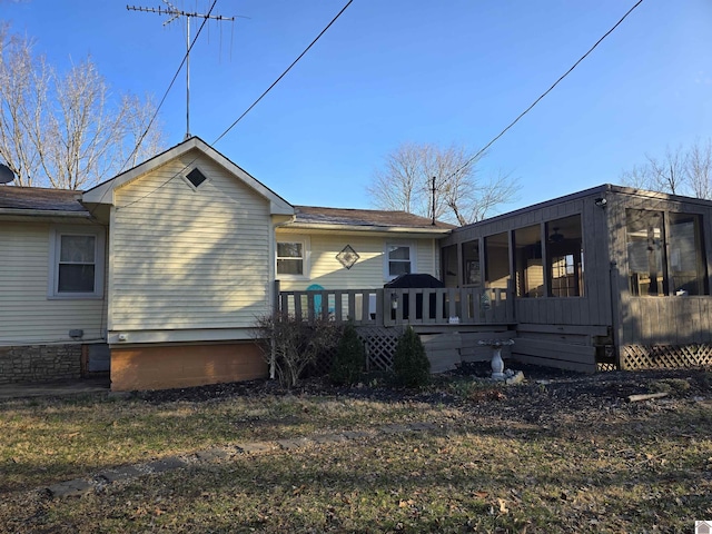 rear view of house featuring a sunroom