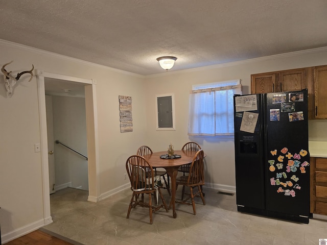 dining space with ornamental molding, electric panel, and a textured ceiling