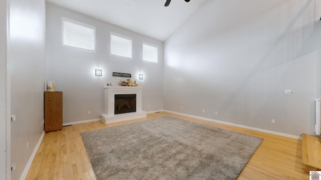 unfurnished living room featuring ceiling fan, high vaulted ceiling, and light hardwood / wood-style flooring