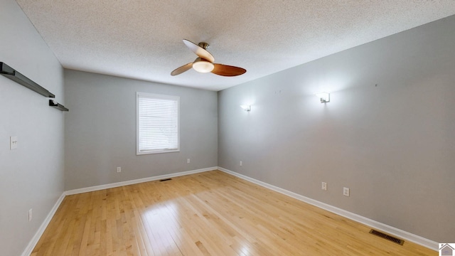 empty room with a textured ceiling, ceiling fan, and light wood-type flooring