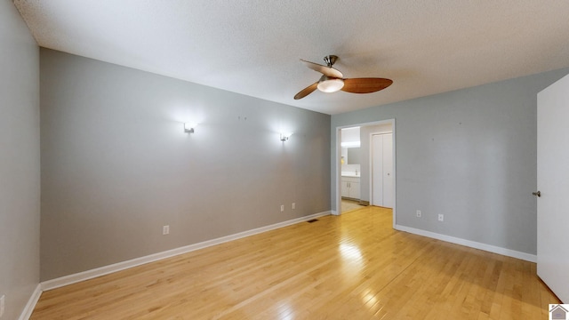 unfurnished bedroom featuring ceiling fan, ensuite bathroom, a textured ceiling, and light wood-type flooring