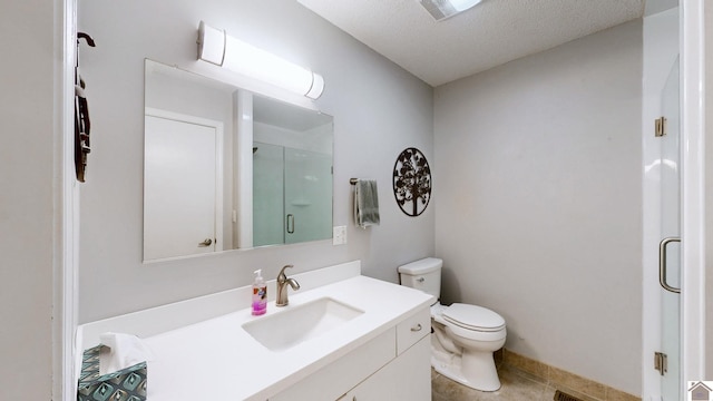 bathroom featuring vanity, toilet, a shower with door, tile patterned floors, and a textured ceiling