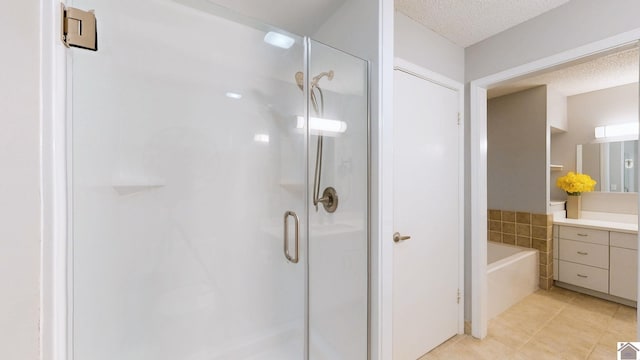 bathroom with independent shower and bath, vanity, tile patterned flooring, and a textured ceiling