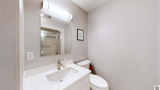 bathroom featuring vanity, toilet, and an enclosed shower