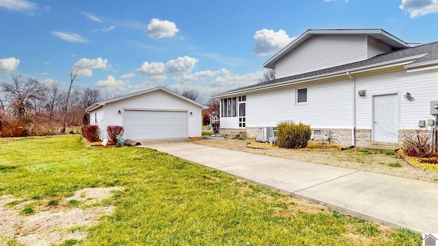 view of side of home featuring an outbuilding, a garage, central AC unit, and a lawn