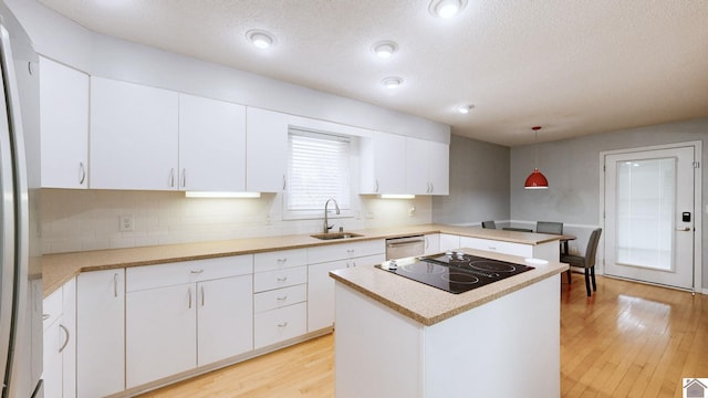 kitchen with a kitchen island, decorative light fixtures, white cabinetry, stainless steel appliances, and light wood-type flooring