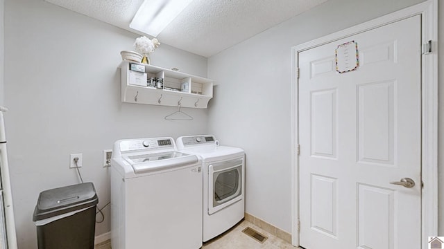 laundry area featuring washing machine and dryer and a textured ceiling