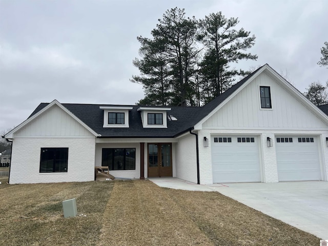 modern inspired farmhouse with a front yard and a garage