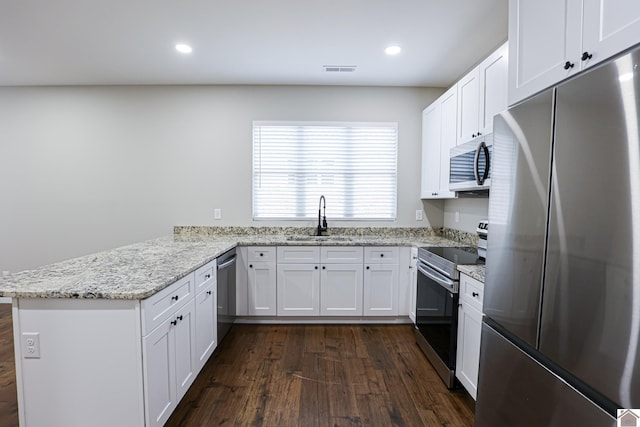 kitchen with white cabinetry, kitchen peninsula, sink, light stone counters, and appliances with stainless steel finishes