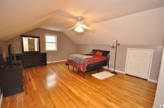 bedroom with ceiling fan, light hardwood / wood-style floors, and lofted ceiling