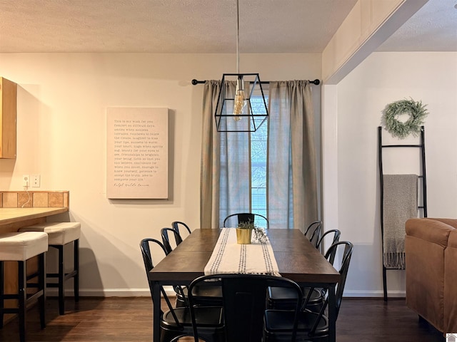 dining room with dark wood-type flooring, a chandelier, and a textured ceiling