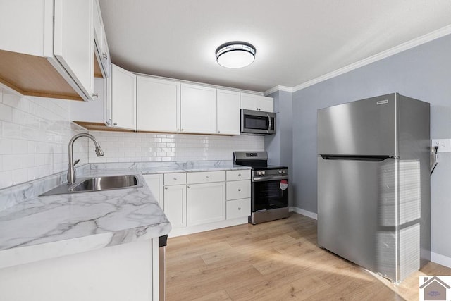 kitchen featuring white cabinetry, light wood-type flooring, stainless steel appliances, sink, and crown molding