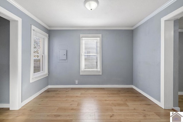 unfurnished room with light hardwood / wood-style floors, electric panel, and crown molding