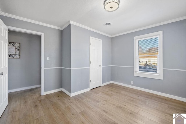 unfurnished bedroom featuring ornamental molding and light wood-type flooring