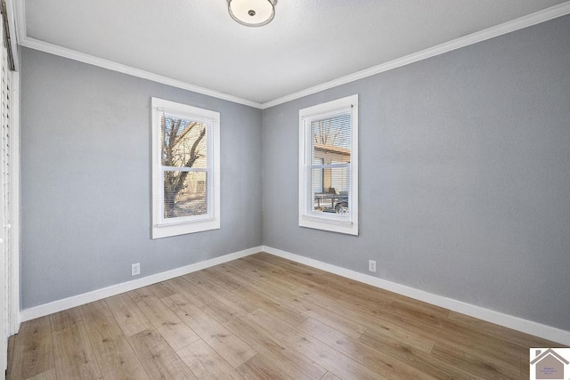 empty room featuring crown molding and light hardwood / wood-style flooring