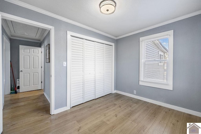 unfurnished bedroom featuring ornamental molding, a closet, and light hardwood / wood-style flooring