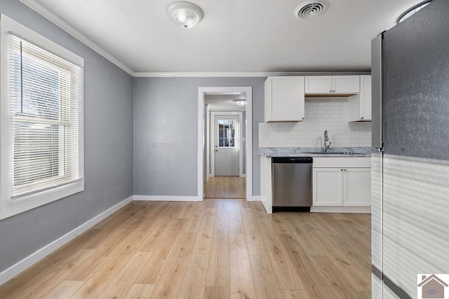 kitchen with light hardwood / wood-style flooring, stainless steel appliances, white cabinetry, and decorative backsplash