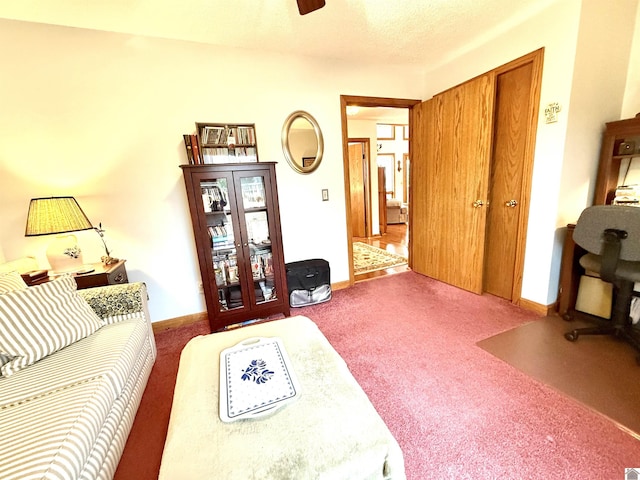 living area featuring dark carpet and baseboards