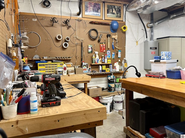 interior space featuring water heater, unfinished concrete flooring, and a workshop area