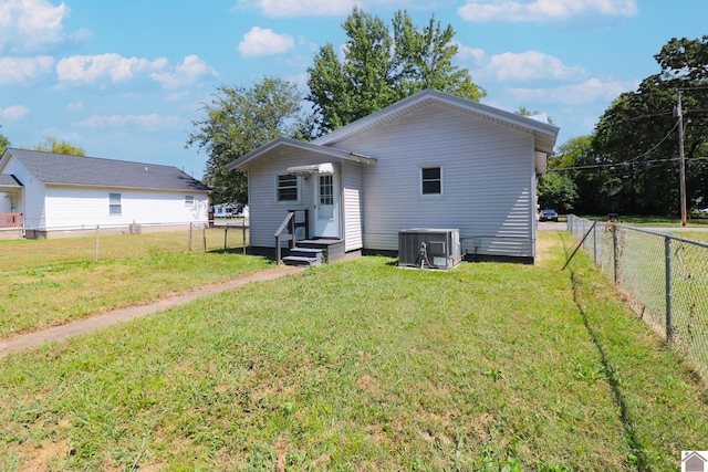 back of house featuring a yard and central AC unit