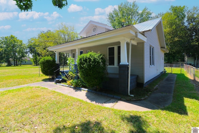 view of side of home with a lawn and a porch