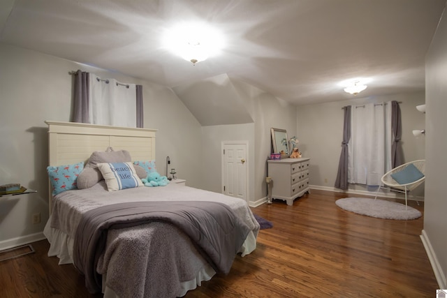 bedroom with vaulted ceiling and dark hardwood / wood-style floors