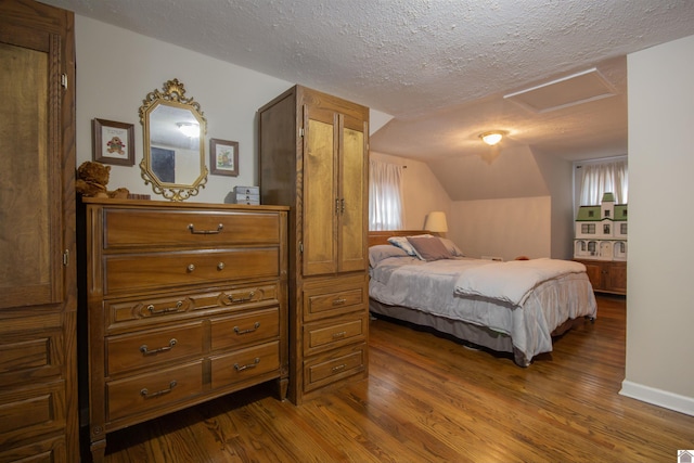 bedroom featuring hardwood / wood-style floors, multiple windows, lofted ceiling, and a textured ceiling