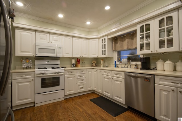 kitchen with white cabinets, stainless steel appliances, and ornamental molding