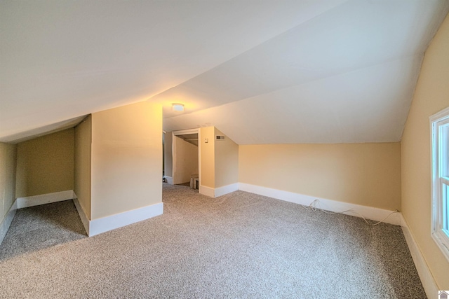 additional living space featuring lofted ceiling, carpet flooring, and baseboards