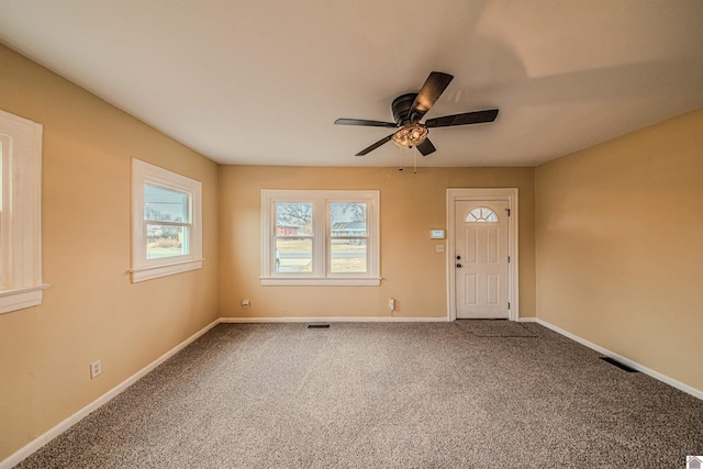 entryway featuring ceiling fan, carpet, visible vents, and baseboards