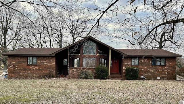 view of front of house with entry steps, crawl space, brick siding, and a front lawn