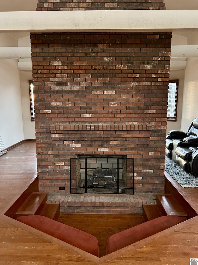 interior details featuring a brick fireplace, wood finished floors, and baseboards