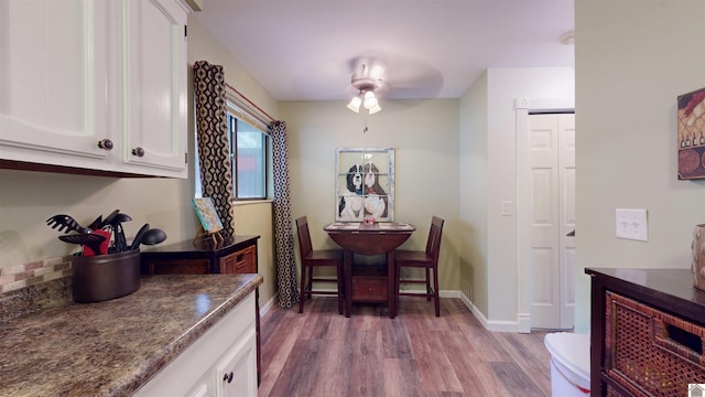 dining room featuring a ceiling fan, light wood-type flooring, and baseboards