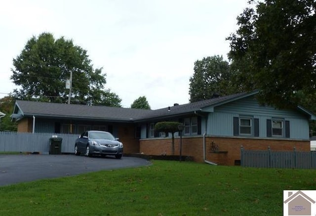 single story home with a front yard, brick siding, driveway, and fence