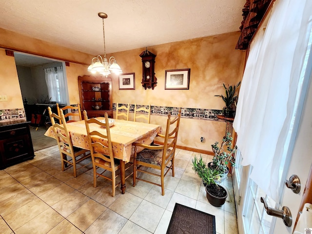 dining room featuring light tile patterned floors, baseboards, a chandelier, and a textured ceiling