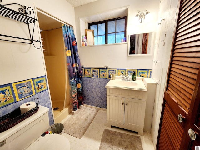 bathroom with a closet, a shower stall, toilet, and vanity