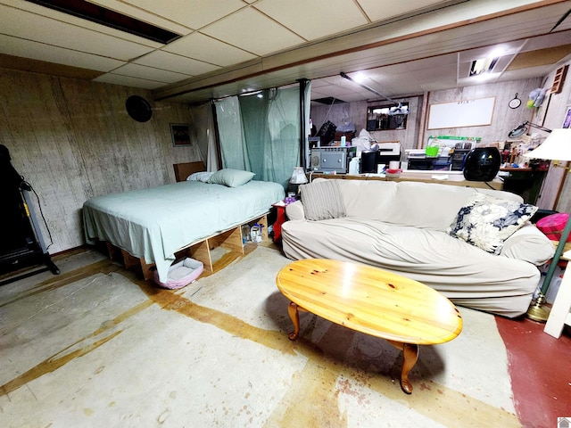 bedroom featuring unfinished concrete flooring and a paneled ceiling