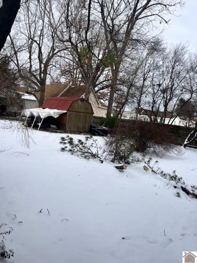 snowy yard featuring fence