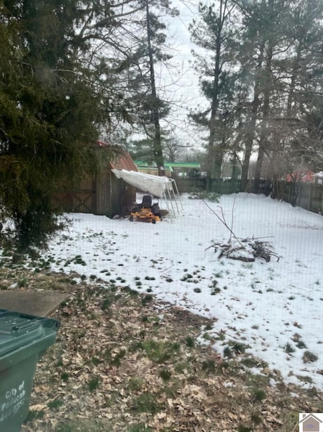 yard layered in snow featuring fence