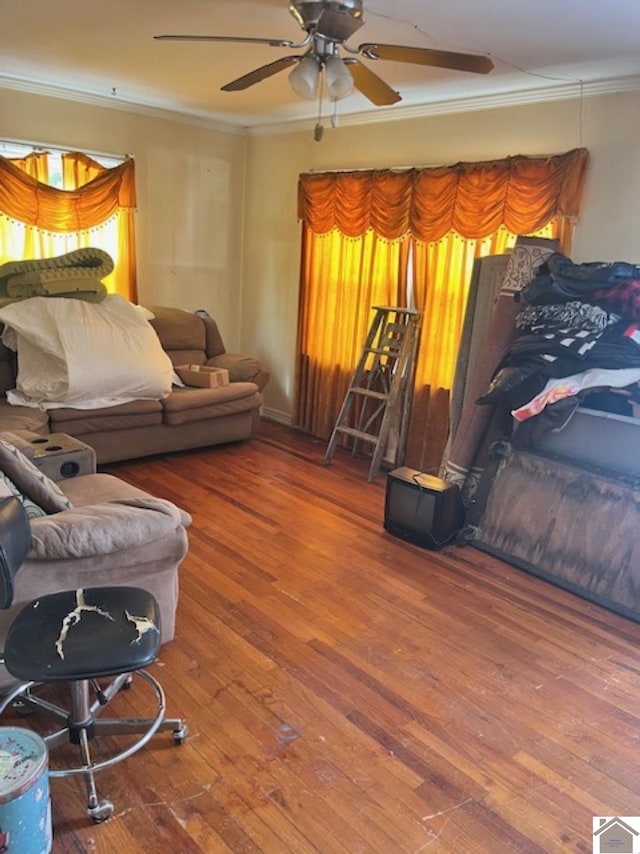 living area with ceiling fan, ornamental molding, and wood finished floors