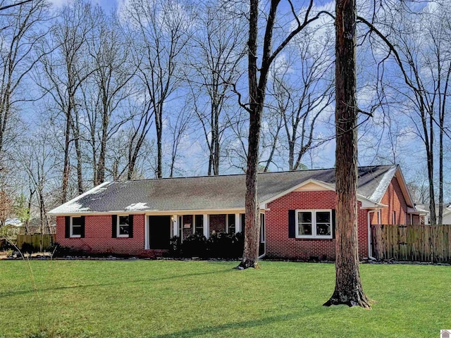 ranch-style home with brick siding, a front yard, and fence